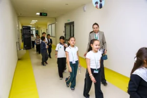 Ученики и педагог в коридоре школы SABIS Astana